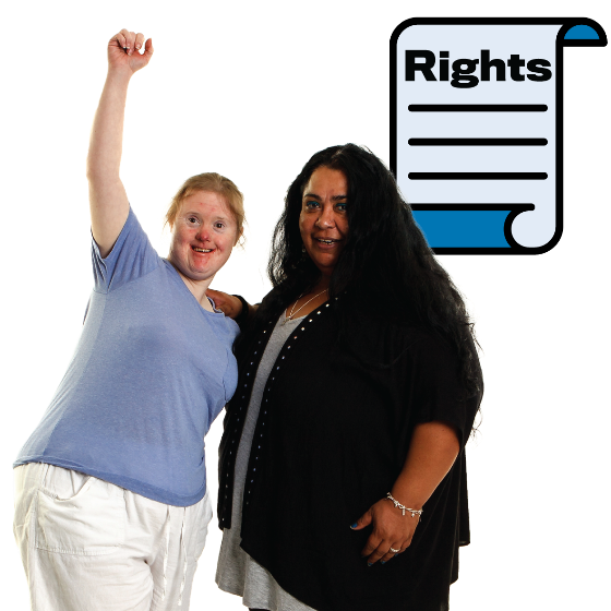A woman with disability raising her fist in the air. She is standing with another woman and there is a rights document next to her